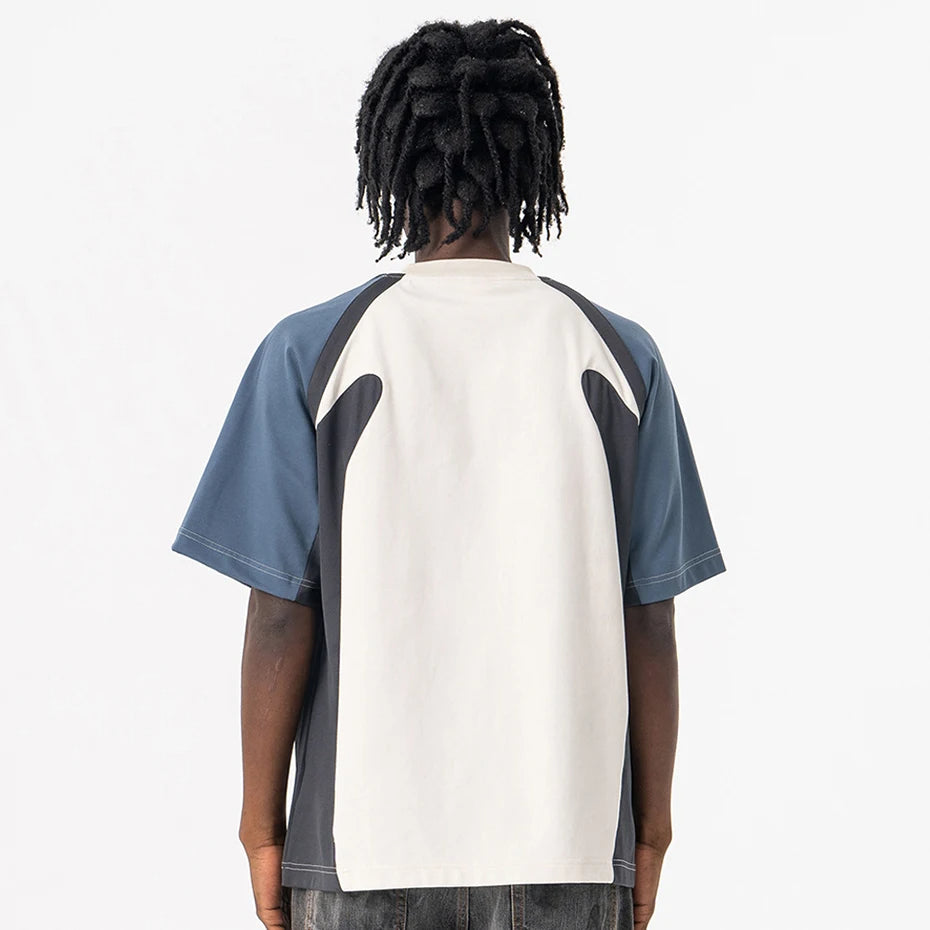 Person wearing a Velocity Panel t-shirt with a white and blue design on a plain background