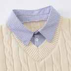 Cream-colored sweater with a blue striped collar on a light gray background