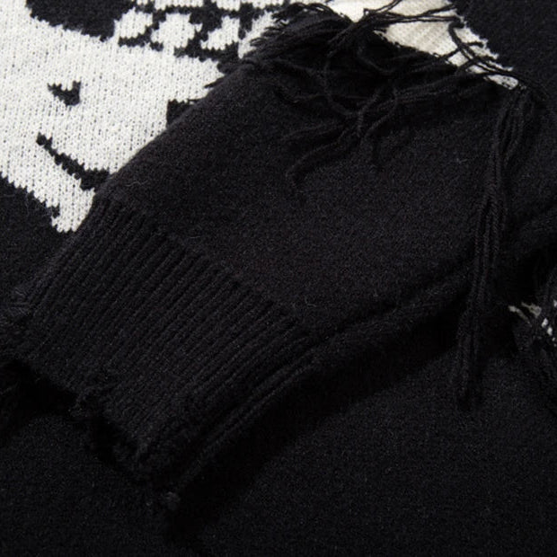 Black sweater with frayed edges on a patterned surface