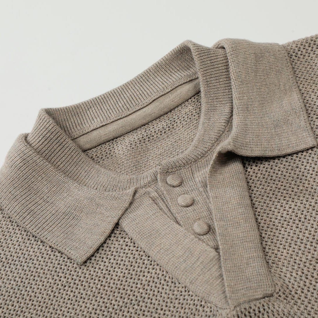 Close-up of a beige knitted polo shirt with buttons on a light gray background