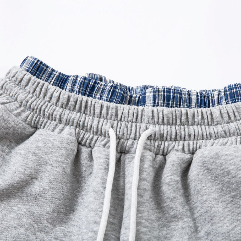Gray sweatpants with plaid lining on a white background