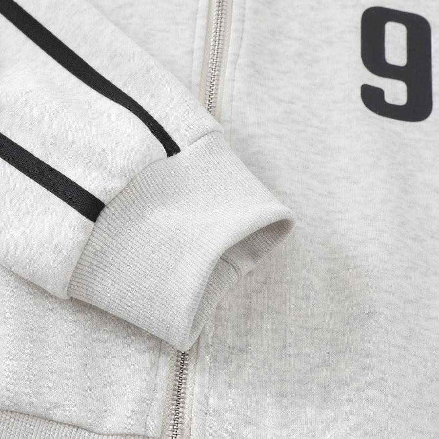 Close-up of a gray jacket with black stripes and a number '9' on a light gray background