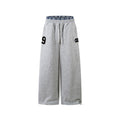 Gray sweatpants with a number 9 and logo on a white background