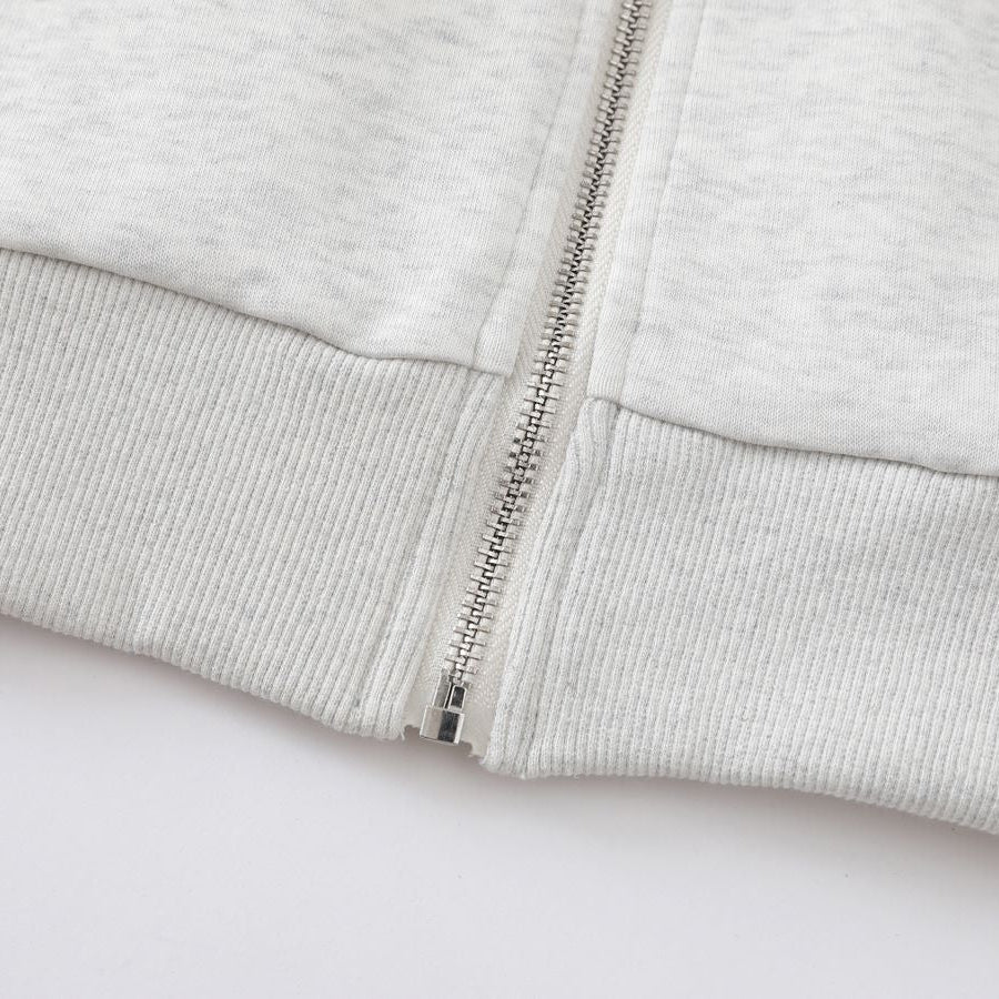 Close-up of a gray zip-up hoodie on a white background