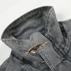 Close-up of a gray denim jacket with a button on a white background