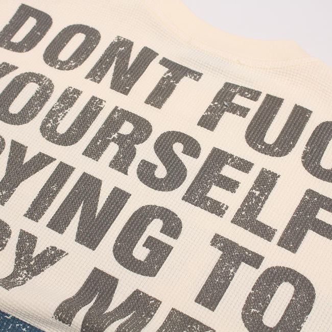 Textured fabric with printed text 'DON'T FUCK YOURSELF TRYING TO COPY ME' on a beige background.