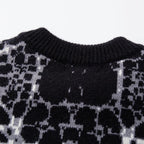 Close-up of a patterned sweater with black and white design on a white background