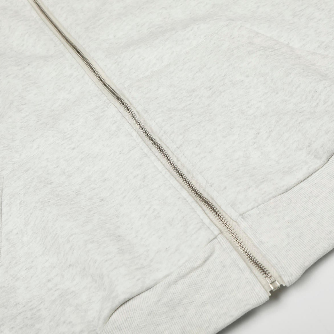 Close-up of a gray zip-up hoodie on a light gray background
