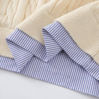 Close-up of a quilt with beige fabric and blue striped lining on a white background