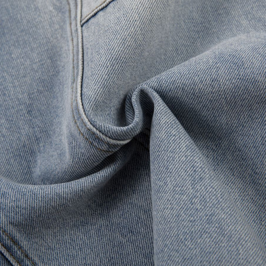 Close-up of blue denim fabric with a gray background