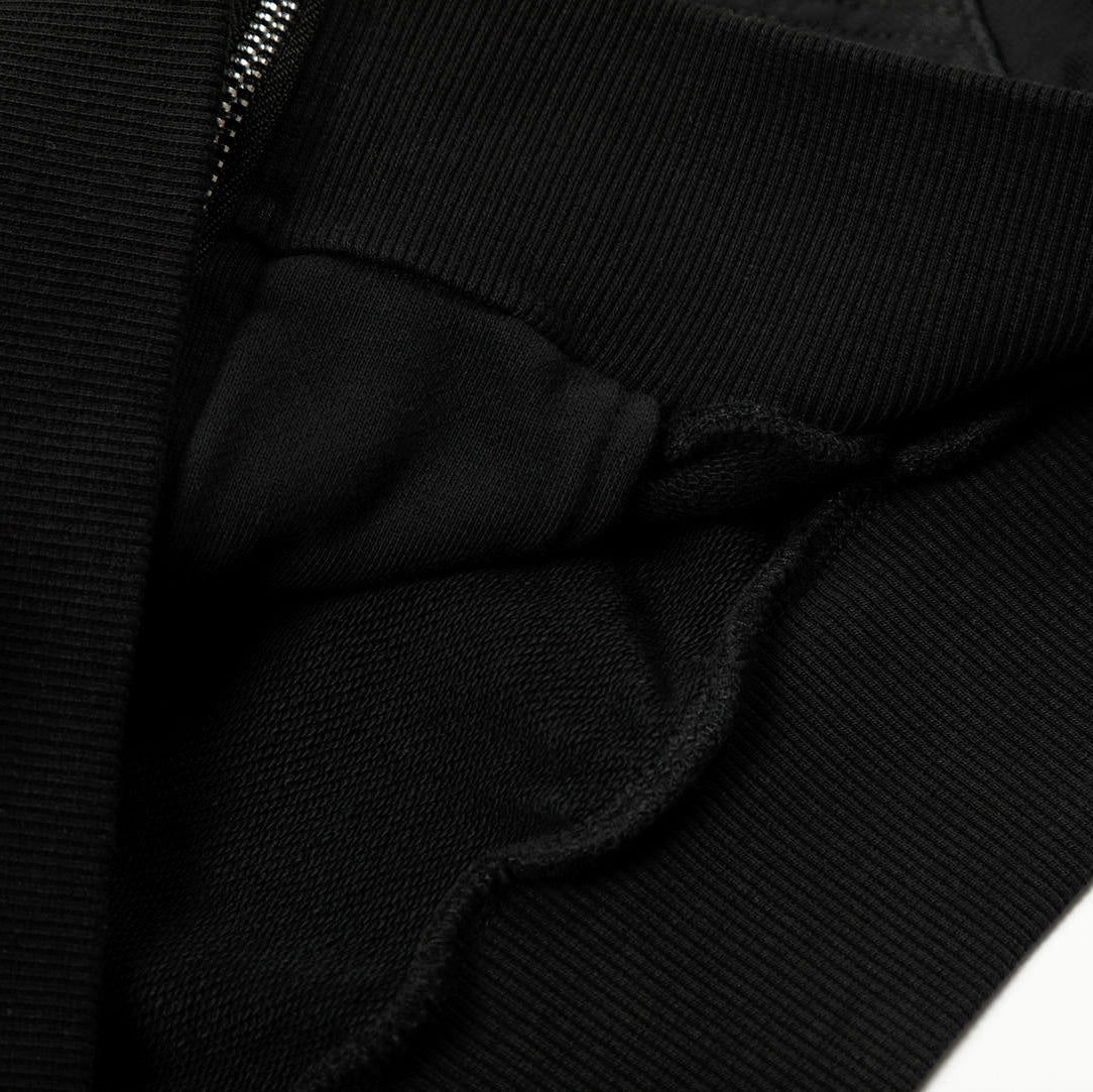 Close-up of a black jacket with a zipper on a white background