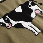 Close-up of a sweater with a cow design on a brown background