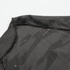 Black camouflage-patterned fabric with visible stitching on a white background