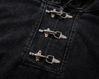 Close-up of black denim fabric with metal buttons on a dark background