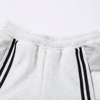 White sweatpants with black stripes on a light gray background
