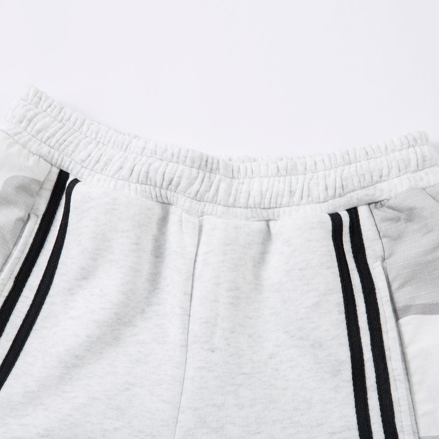 White sweatpants with black stripes on a light gray background