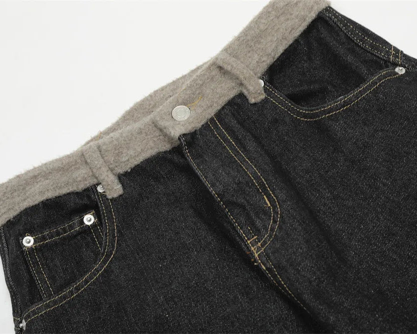 Close-up of black jeans with a gray fleece lining on a white background