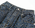 Close-up of blue denim jeans with a subtle pattern on a white background