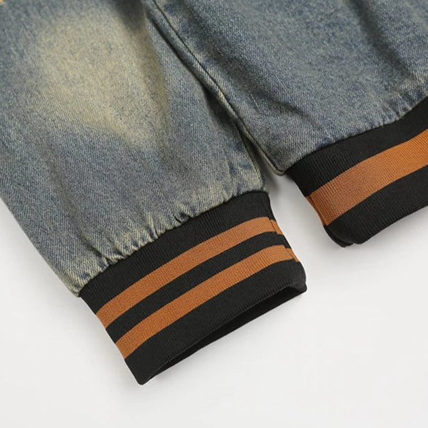 Close-up of denim pants with brown and black striped cuffs on a light gray background