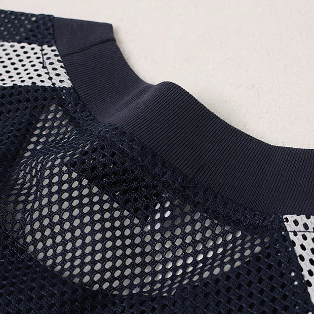 Navy blue athletic jacket with mesh design on a light gray background