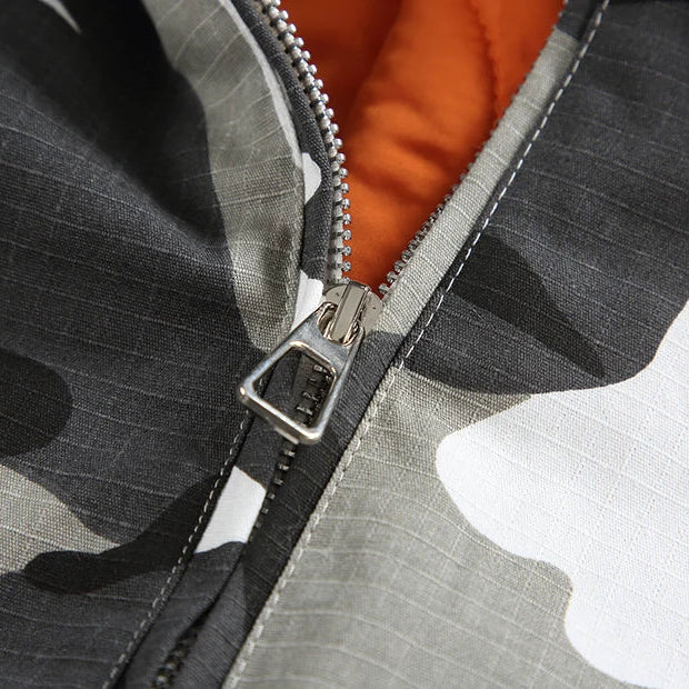 Close-up of a zipper on a camouflage-patterned jacket with orange lining.