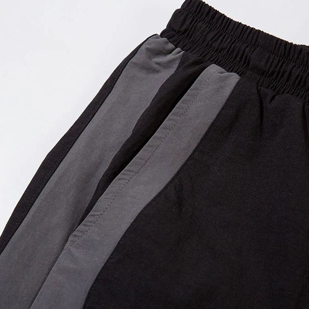 Close-up of black pants with gray stripes on a white background