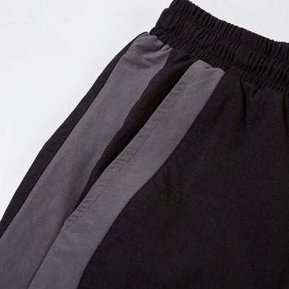 Close-up of black pants with gray stripes on a white background