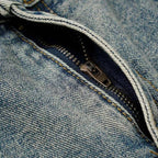 Close-up of a zipper on blue denim fabric