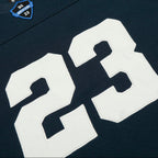 Navy blue sports jersey with large white number 23 and a logo on the chest.