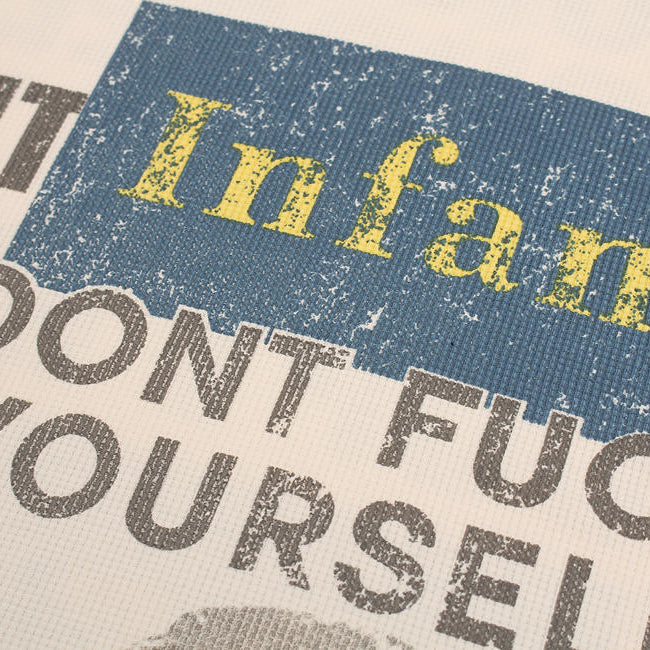 Textured fabric with printed text including 'Infant' and 'Don't Fuc Yourself' on a blue and gray background.