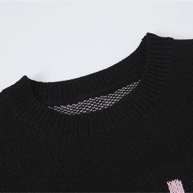 Close-up of a black sweater with a textured neckline on a light gray background
