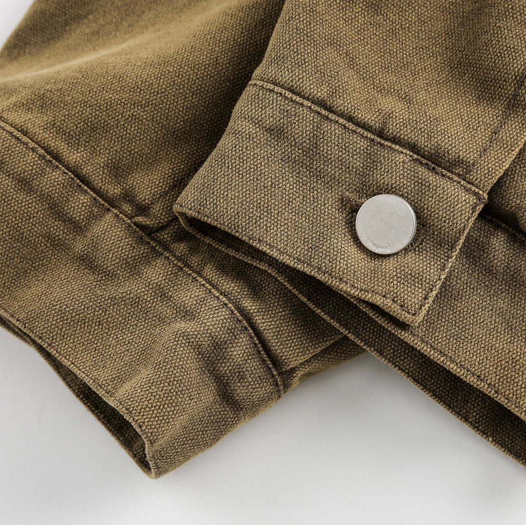 Close-up of a brown fabric jacket with a button on a white background from honeybear clothing