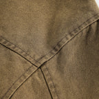 Close-up of brown fabric with stitching detail on a light gray background from h0neybear aka honeybear clothing