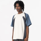 Person wearing a Velocity Panel t-shirt with a white and blue design on a plain background